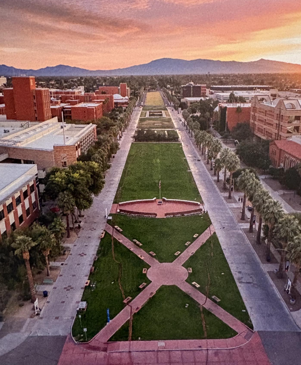 Aerial view at sunset of the USS Arizona Memorial Mall at the University of Arizona, a full-scale deck outline on the central lawn between palm-lined walks.